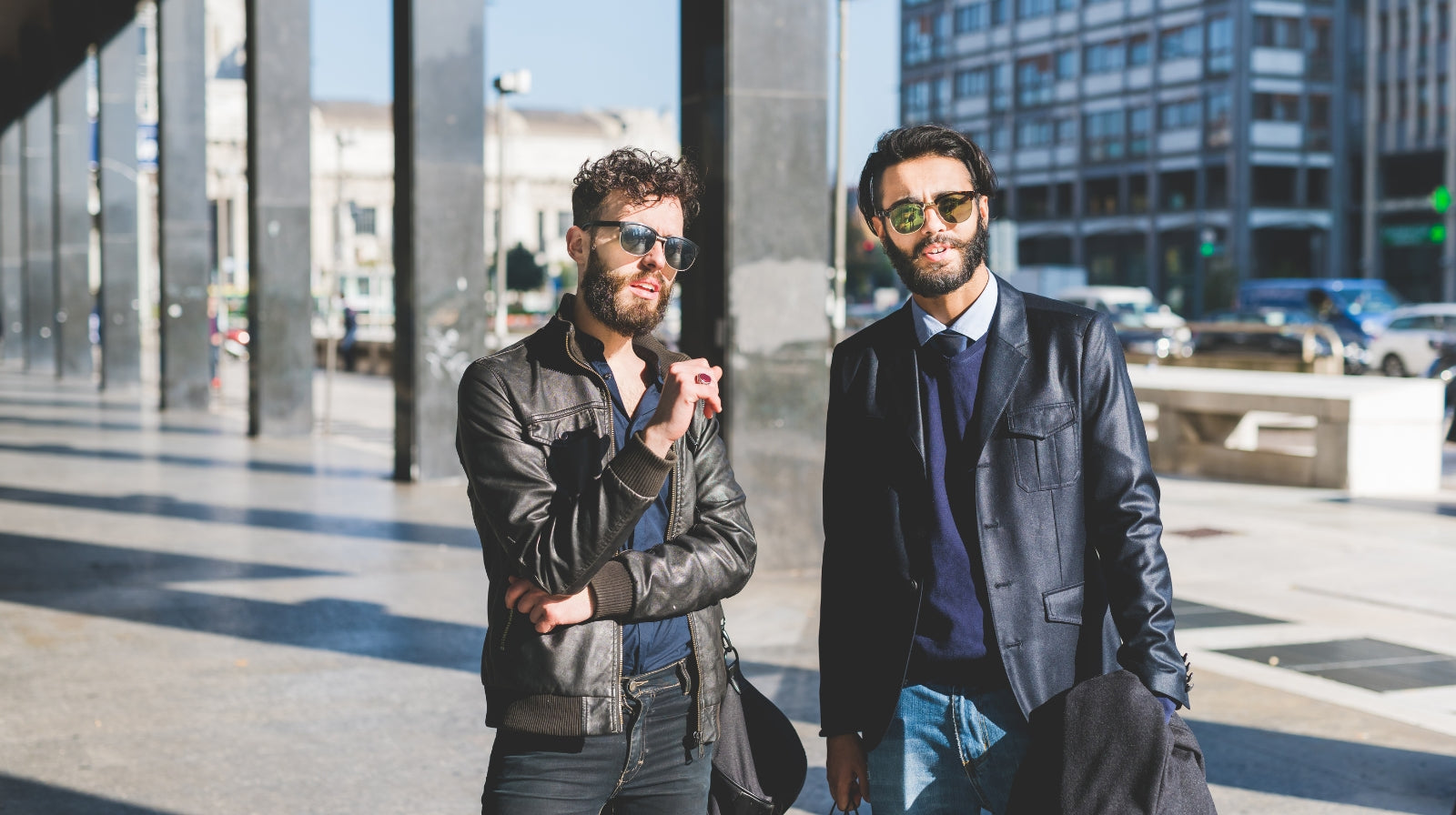 Men styling leather jackets with smart casual looks on a modern city street.