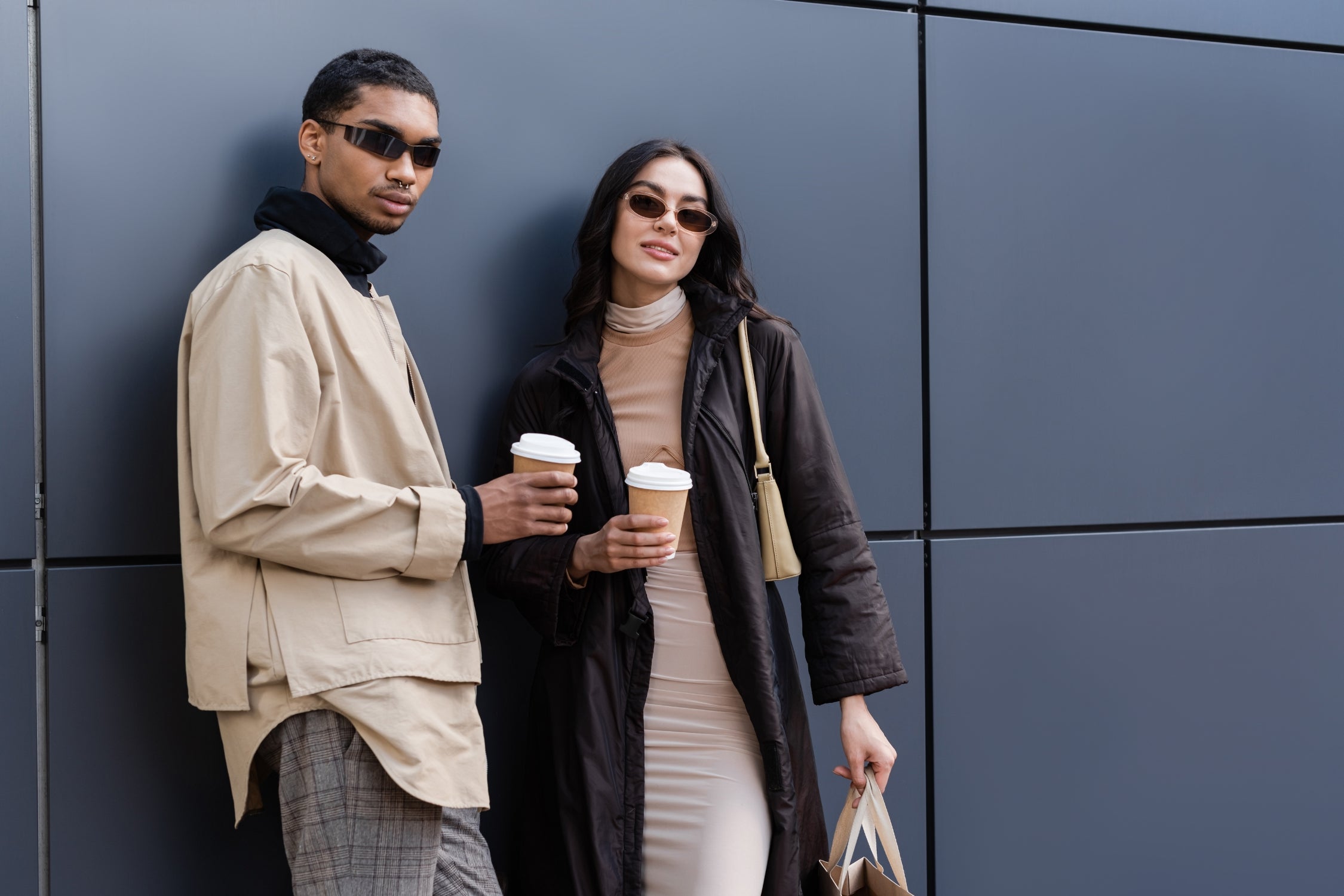Stylish couple holding coffee in layered outerwear for Winter 2025 Fashion Trends.