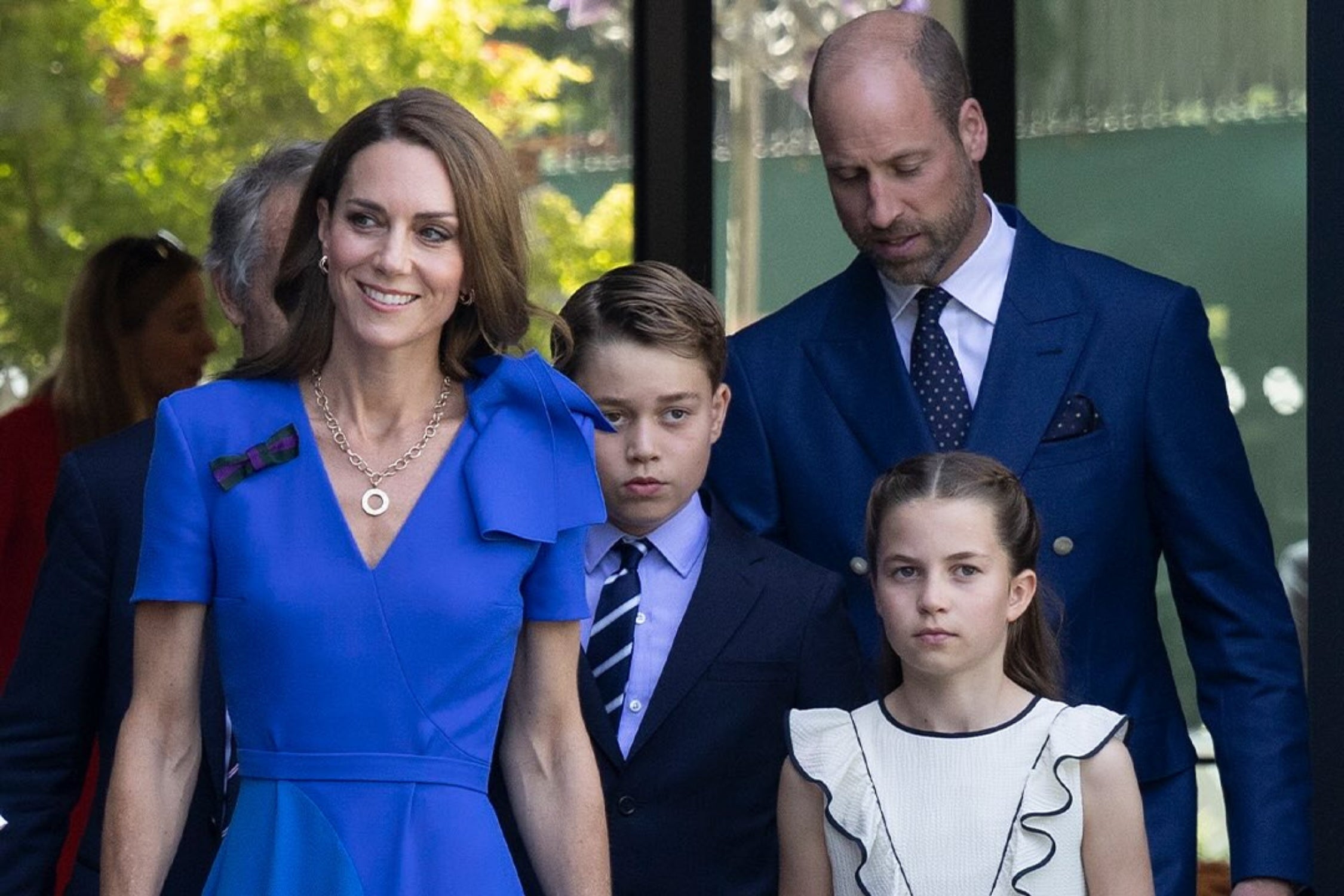 The Princess of Wales wearing a royal blue dress with a statement bow and tartan pin at Wimbledon 2025
