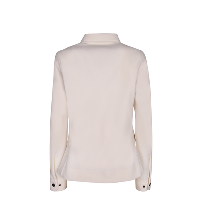 Shirt collar. Front closure with contrasting black buttons. Flap pockets on the chest.