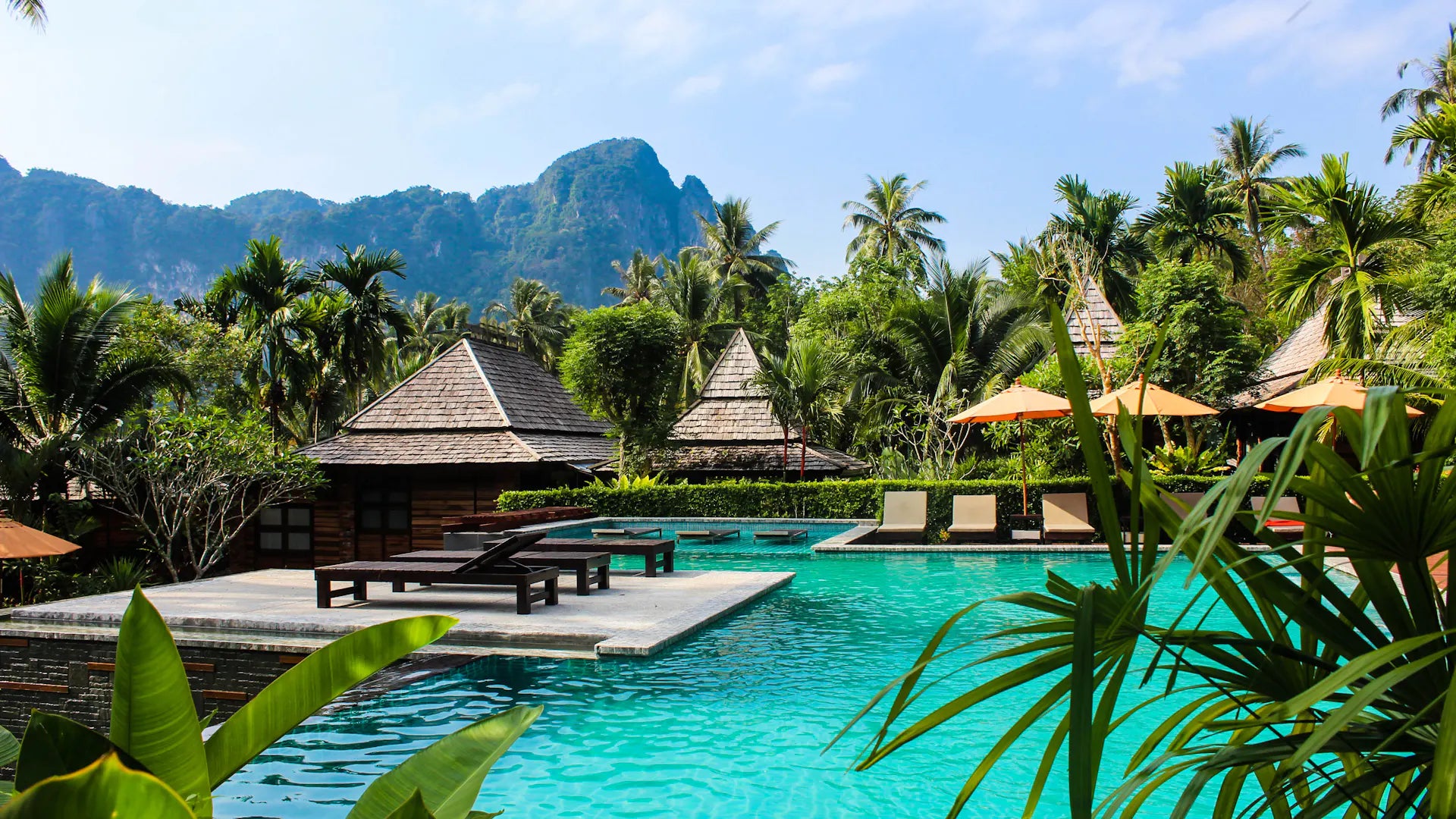 A pool and shaded loungers surrounded by tropical planting in Ao Nang, Thailand